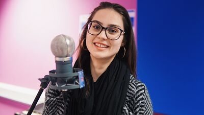 Image of young woman in front of studio microphone