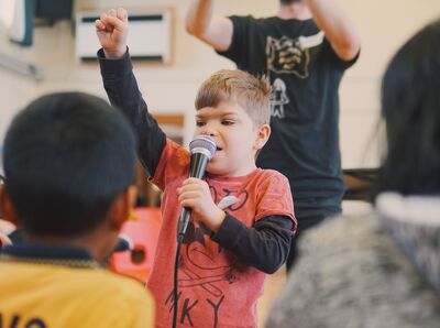 Young boy singing into microphone